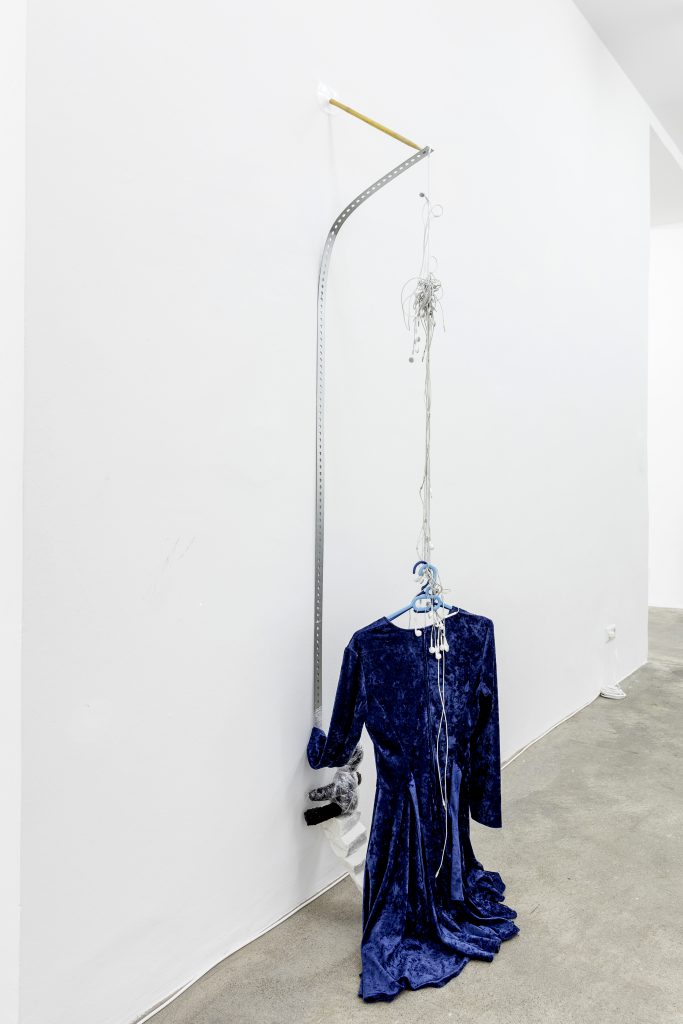 Sophie Jung, Ornament And Climb, 2017 Blue velvet dress, two clothes hangers, headphones, zink plated bar, Carrara marble, teddy from artist’s collection, cling film, drum stick, dimensions variable. Photography: www.kunst-dokumentation.com. Courtesy: Sophie Tappeiner